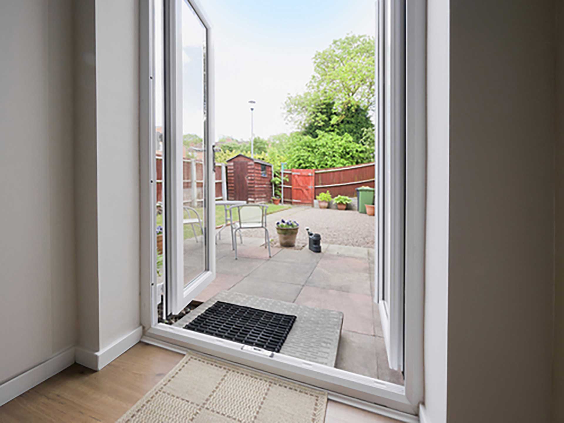 Liniar french doors opened out onto a family home patio and garden